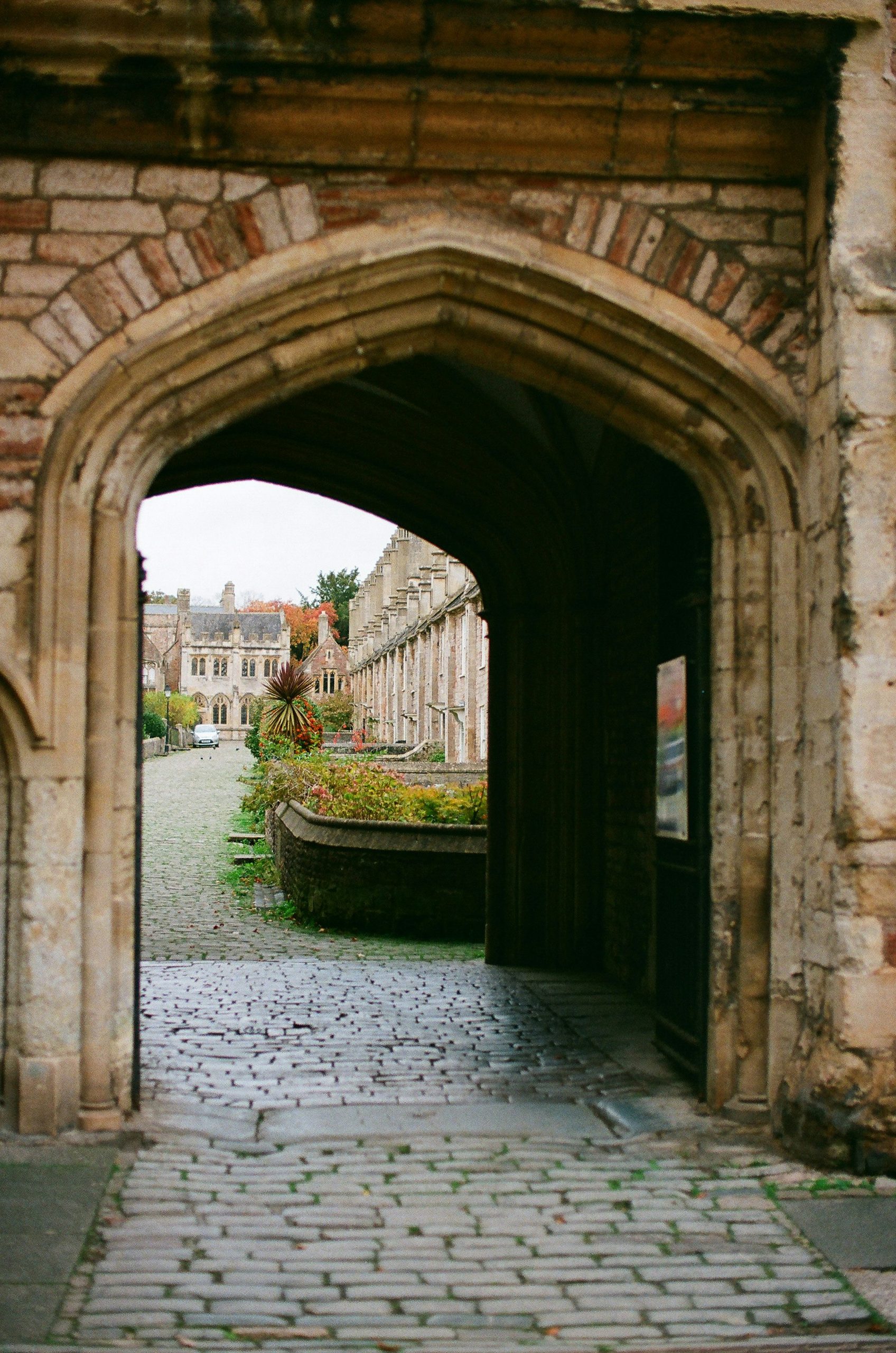 A stone archway onto a cobbled courtyard
