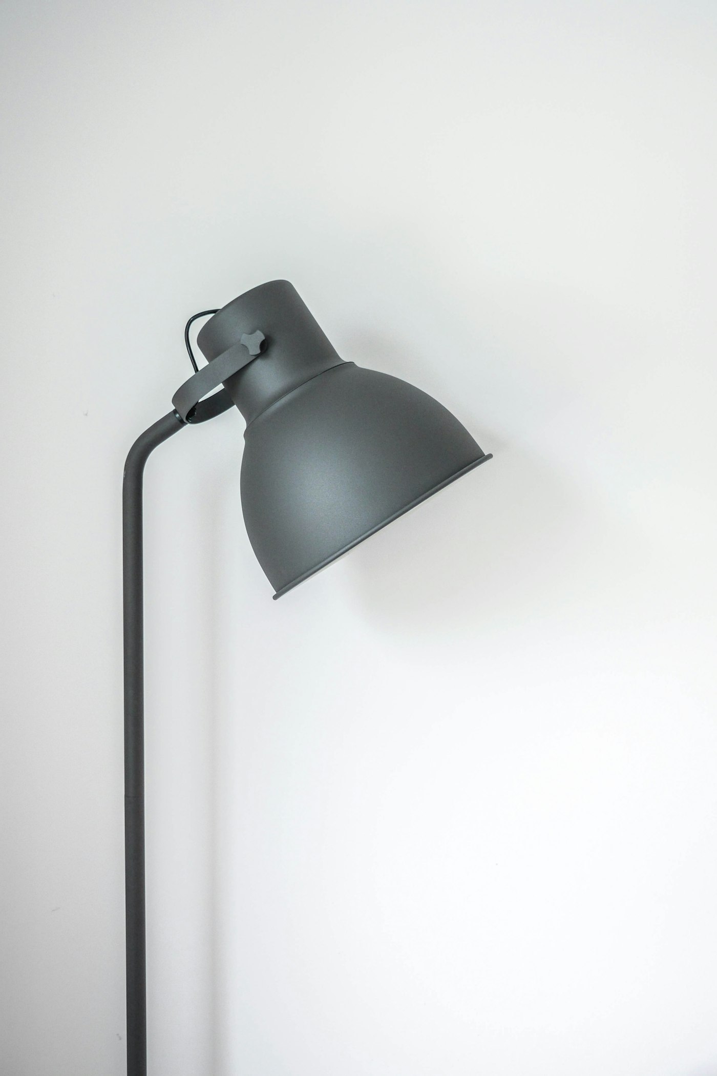 A grey floor lamp with an angled shade