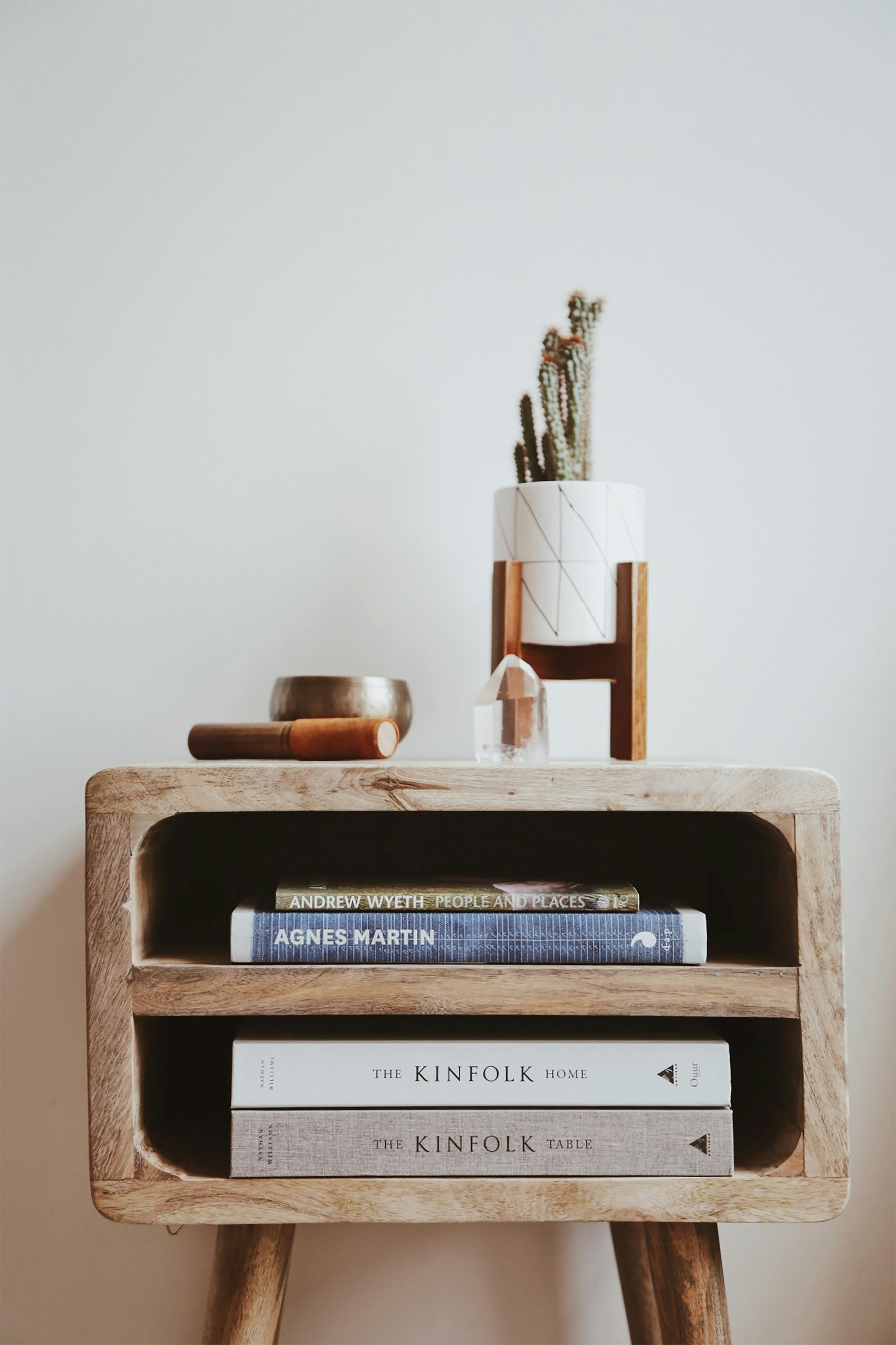 A low oak bench with books and a plant