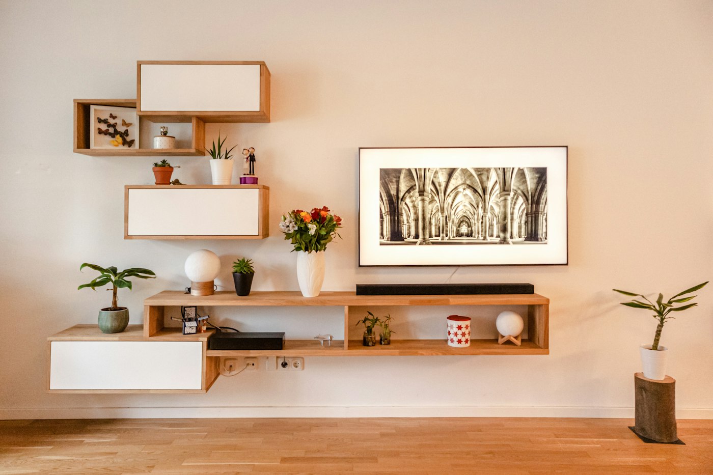 A tall wooden shelving unit on a pink wall