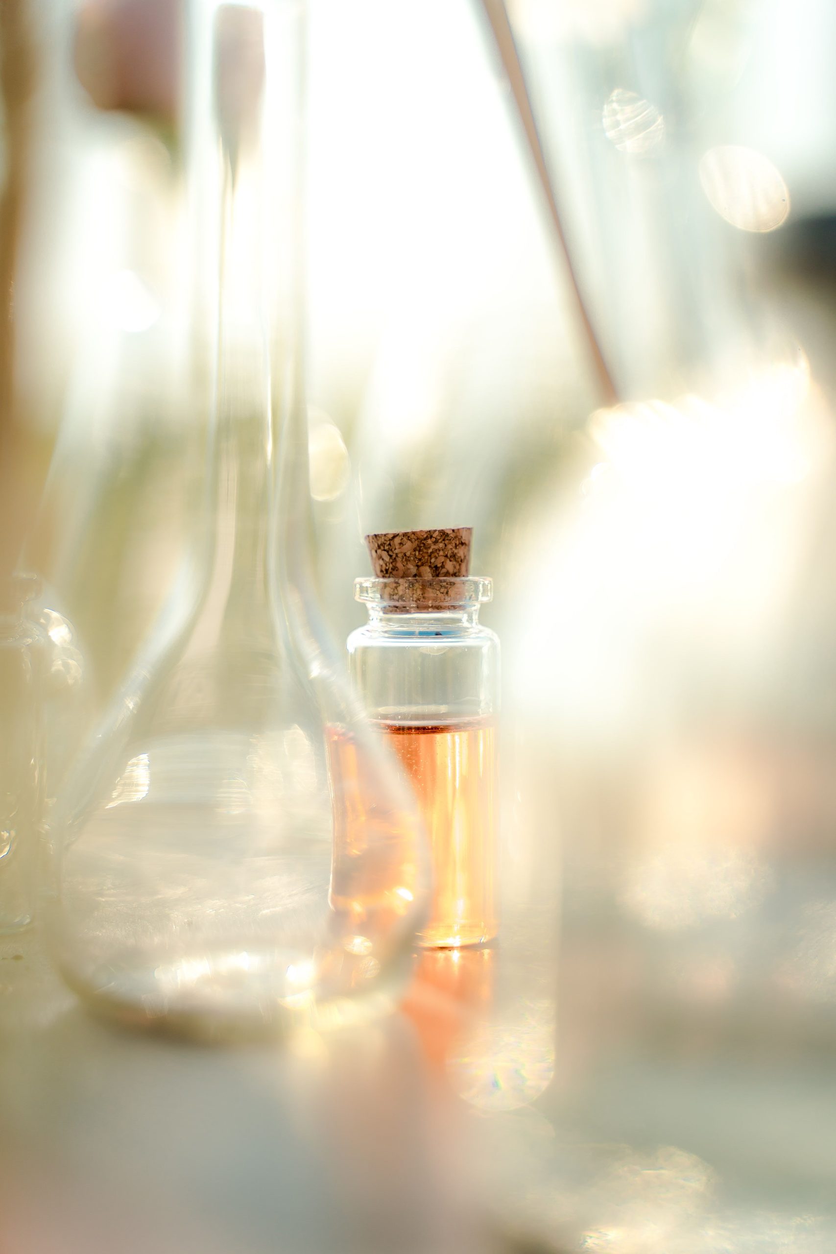 Small glass bottles catching warm window light on a table