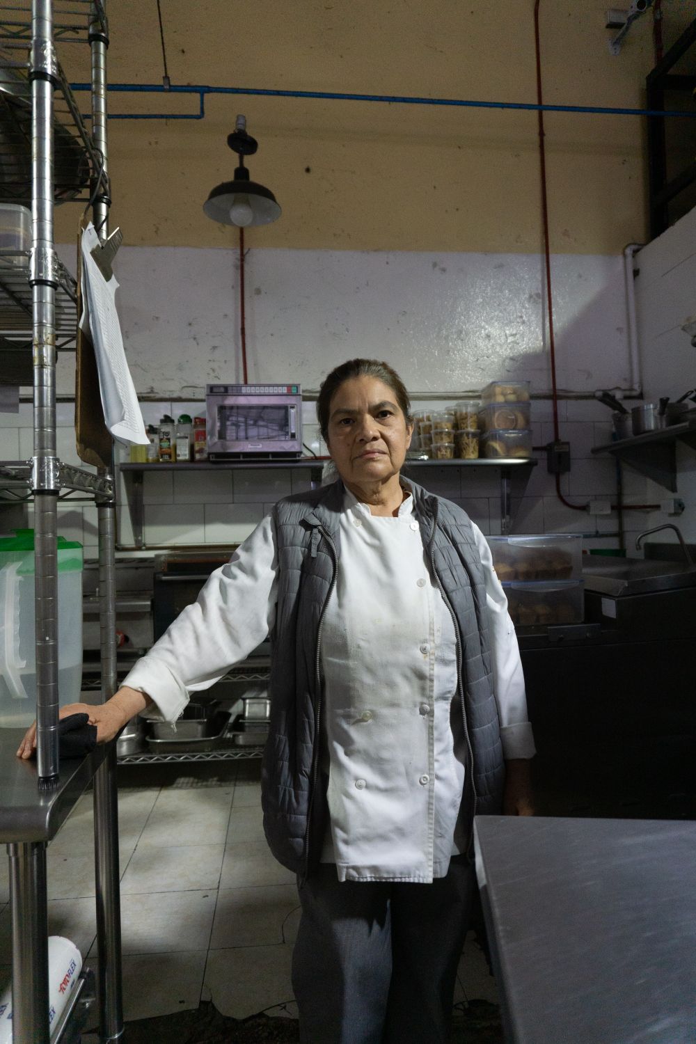Chef Revathi in her chef’s jacket in the restaurant kitchen