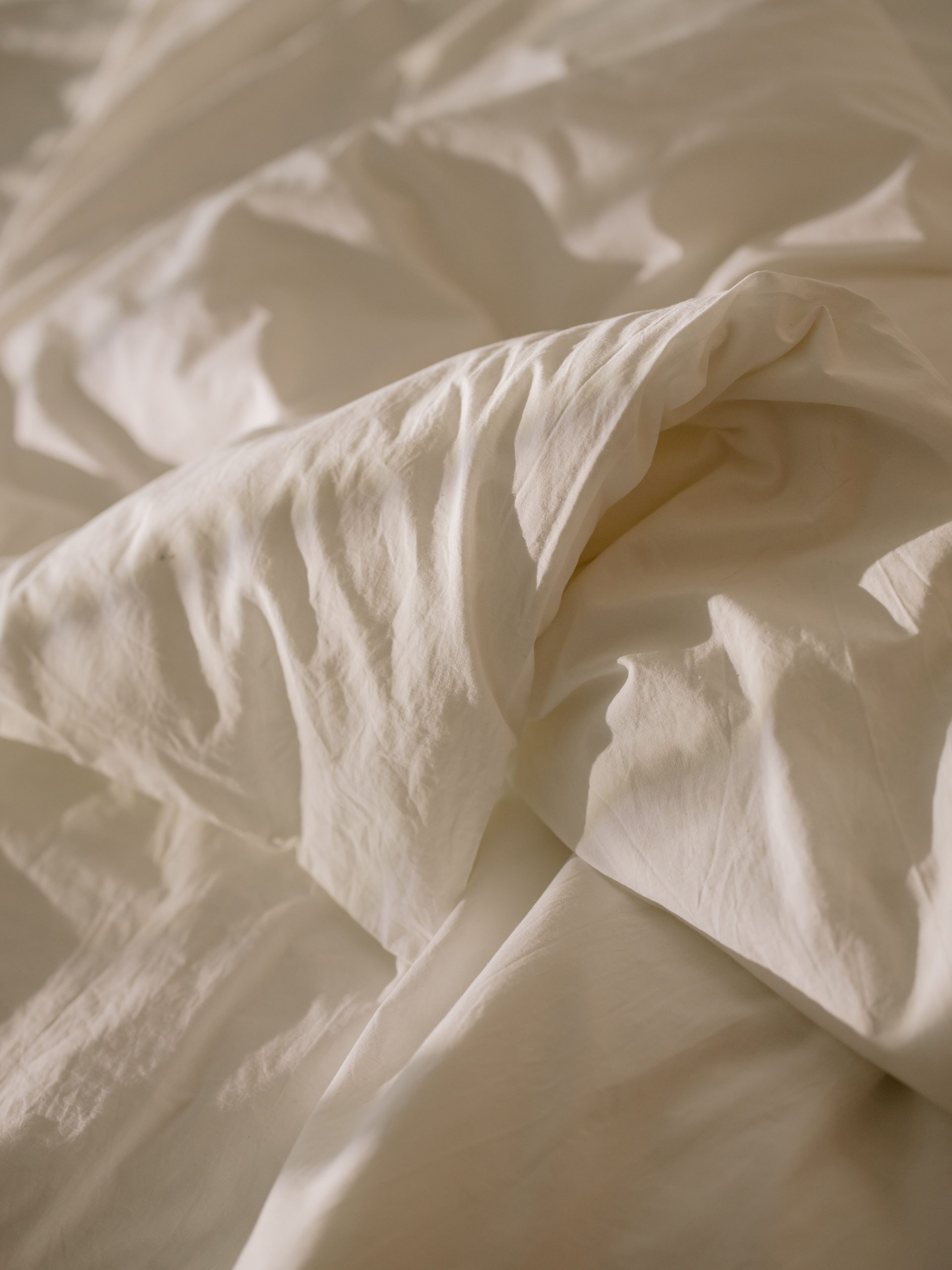 Creased white linen in warm light