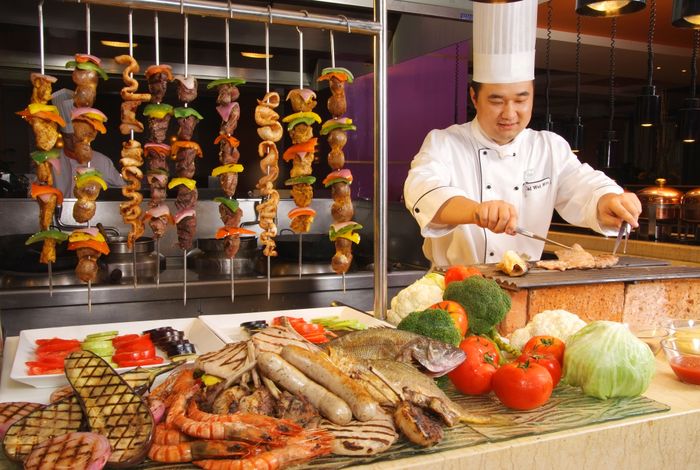 A chef plating at a live counter in front of guests